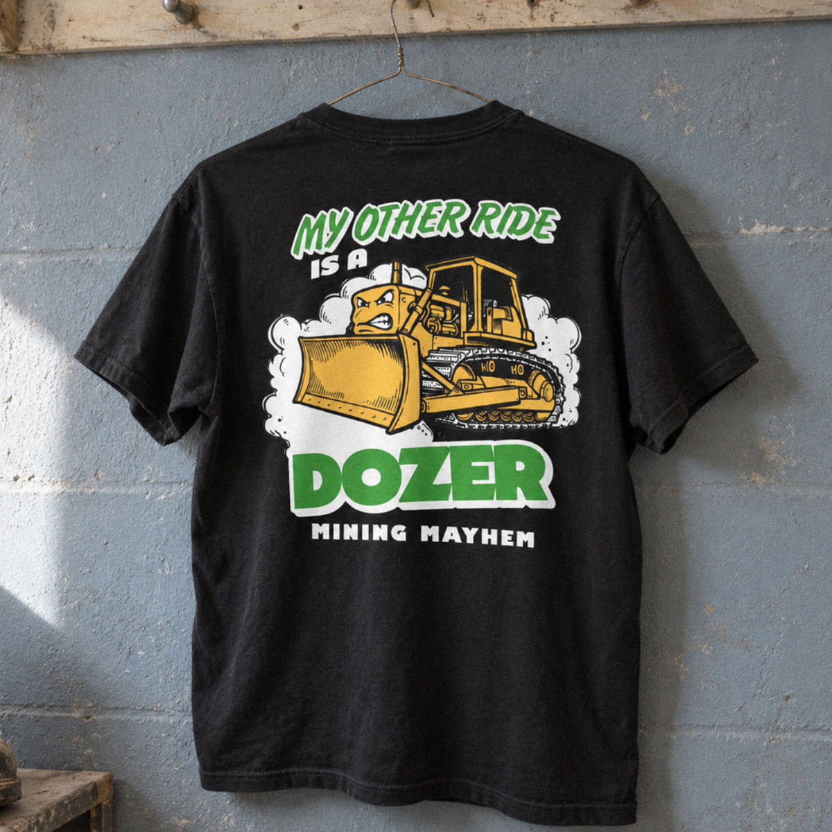 Black Dozer t-shirt hanging on a boot room peg rail, back print