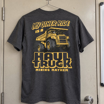 Charcoal Haul Truck t-shirt hanging on a site office door, back print