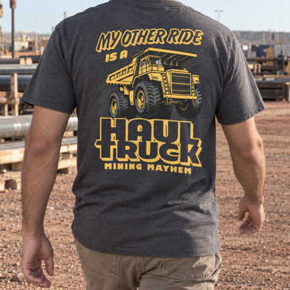 Miner wearing the charcoal Haul Truck t-shirt walking through a laydown yard