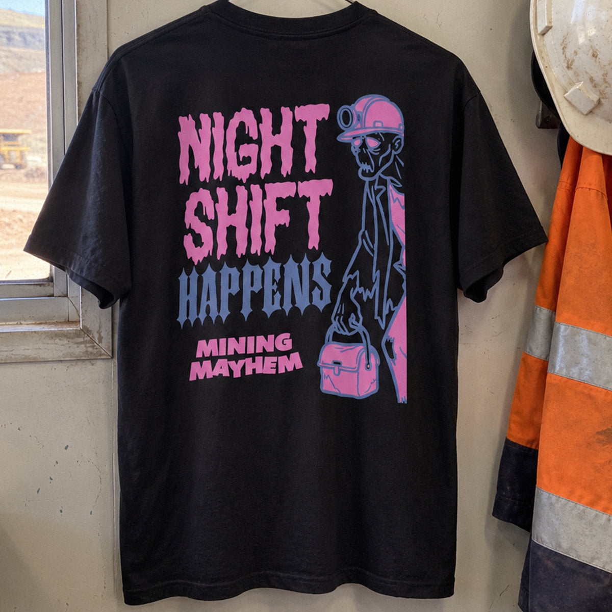 Black Night Shift Happens t-shirt hanging in a site crib room, back print