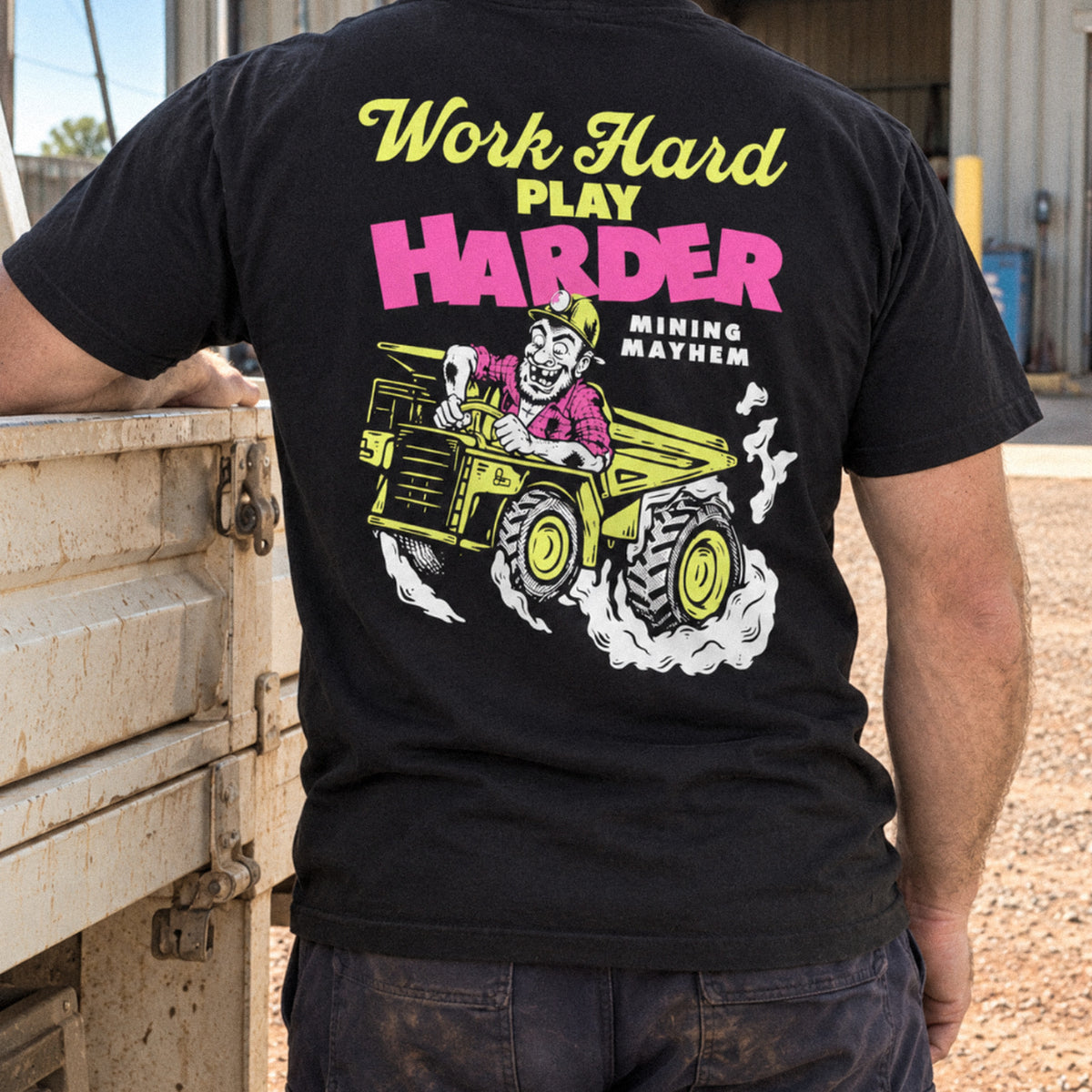 Miner wearing the Work Hard Play Harder t-shirt on site beside a ute